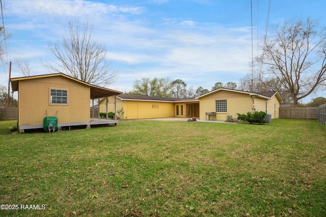 view of yard featuring a carport, a patio area, fence, and an outdoor structure