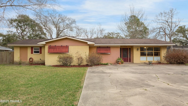 ranch-style home with a front yard, brick siding, and fence