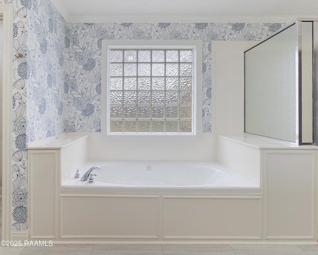 bathroom with wallpapered walls, a garden tub, and crown molding