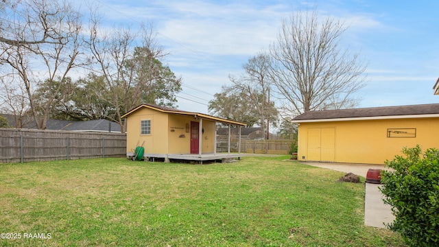 view of yard featuring a storage unit, an outdoor structure, and a fenced backyard