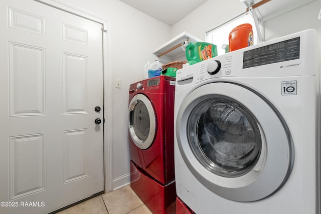 laundry area featuring light tile patterned floors, laundry area, and washer and clothes dryer