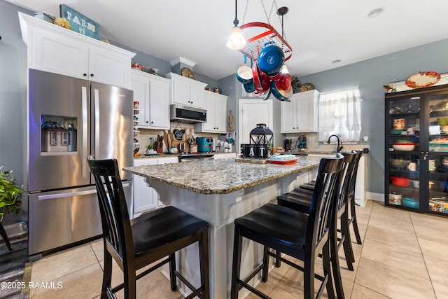 kitchen featuring a center island, decorative backsplash, appliances with stainless steel finishes, and white cabinetry