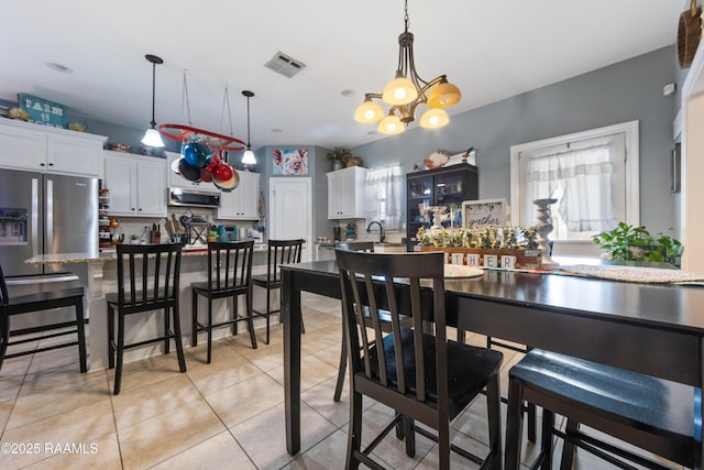 dining space featuring light tile patterned flooring, visible vents, and a chandelier