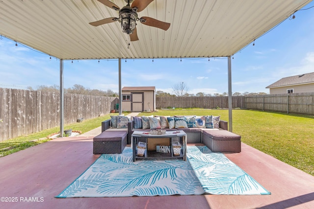 view of patio / terrace featuring an outbuilding, a fenced backyard, a storage shed, outdoor lounge area, and ceiling fan