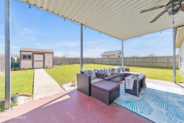 view of patio / terrace with a storage unit, a fenced backyard, an outdoor structure, an outdoor hangout area, and ceiling fan