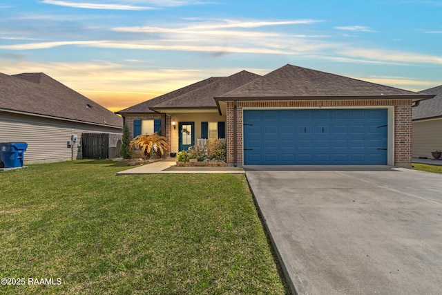 ranch-style home featuring driveway, brick siding, roof with shingles, and a front lawn