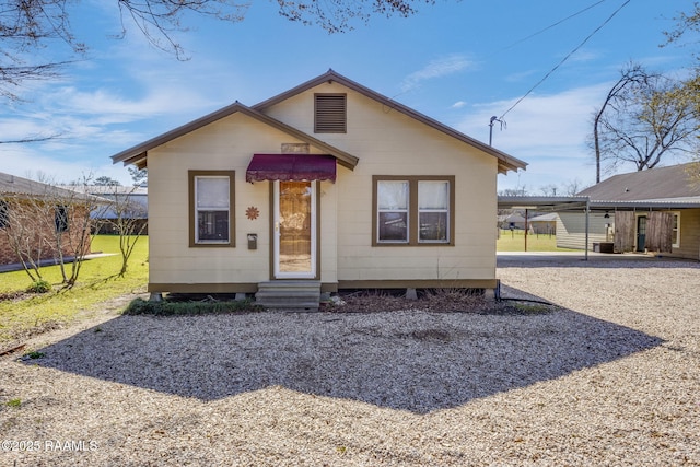 bungalow-style house featuring entry steps and a front lawn