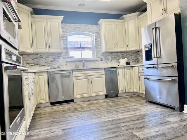 kitchen with stainless steel appliances, light wood-style floors, backsplash, and crown molding