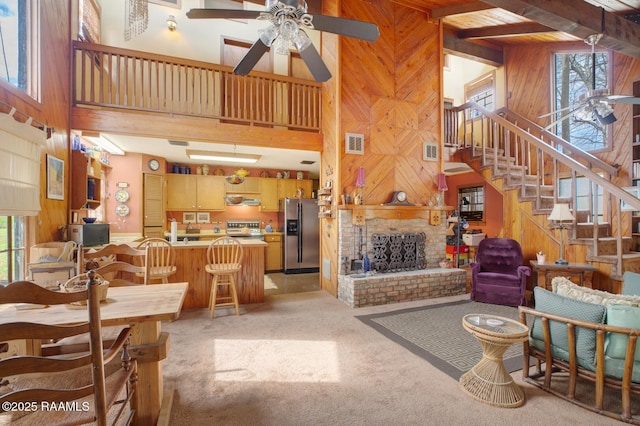 living room with a healthy amount of sunlight, a brick fireplace, visible vents, and wooden walls