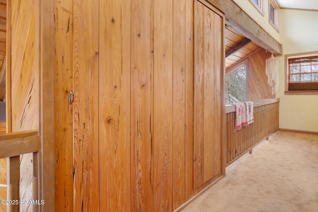 interior space with carpet floors, wooden walls, and baseboards