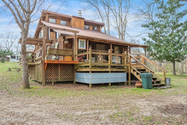 rear view of property featuring a deck, metal roof, and stairway