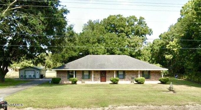 single story home with driveway, a front yard, and an outdoor structure