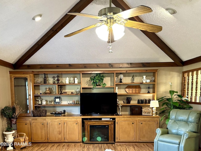 living room featuring light wood-style flooring, lofted ceiling with beams, and a textured ceiling