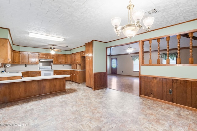 1410 S Chataignier Rd, Ville Platte, LA 70586 - kitchen featuring white electric range oven, ceiling fan, under cabinet range hood, brown cabinetry, and wainscoting