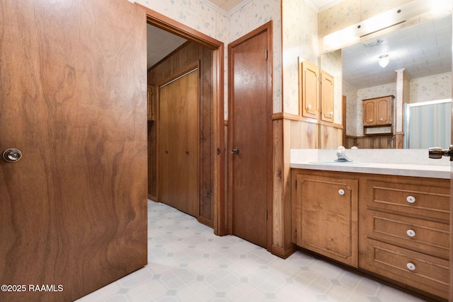 1410 S Chataignier Rd, Ville Platte, LA 70586 - bathroom featuring wallpapered walls, vanity, a wainscoted wall, and tile patterned floors