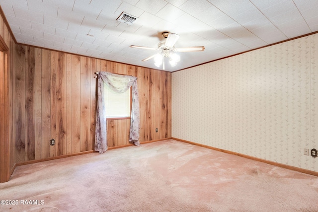 1410 S Chataignier Rd, Ville Platte, LA 70586 - empty room featuring a ceiling fan, carpet, wooden walls, and crown molding
