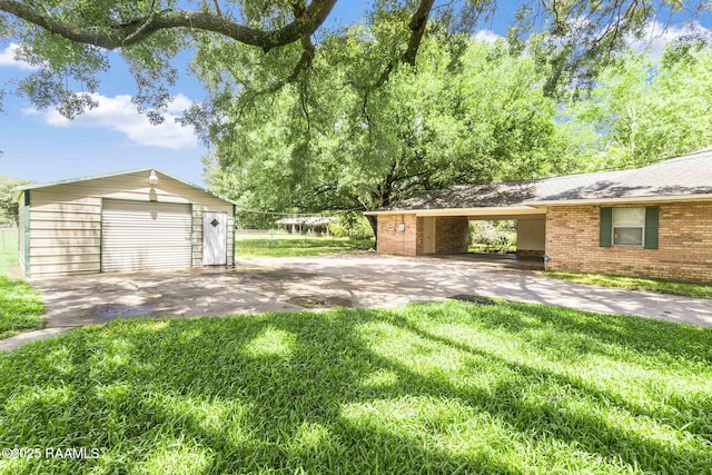 1410 S Chataignier Rd, Ville Platte, LA 70586 - view of grassy yard featuring an outbuilding, a detached garage, and asphalt driveway