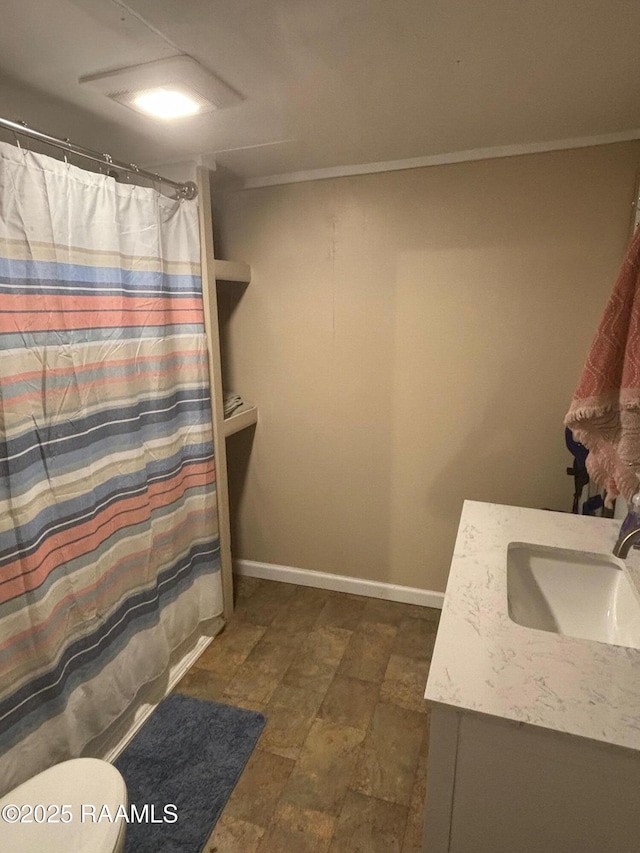 bathroom featuring toilet, curtained shower, baseboards, and vanity