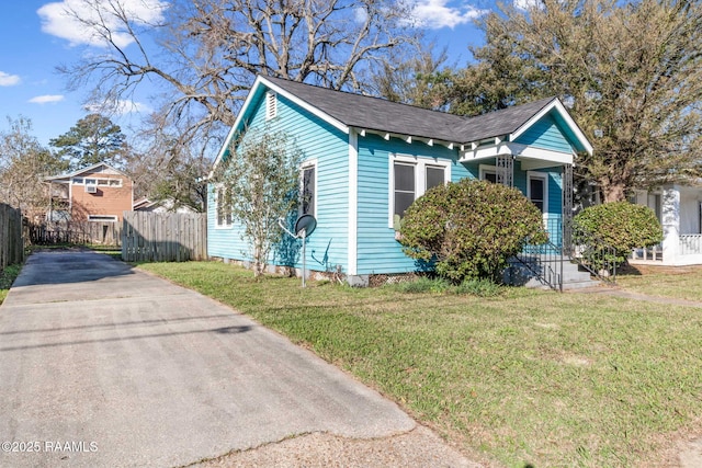 bungalow featuring fence and a front lawn