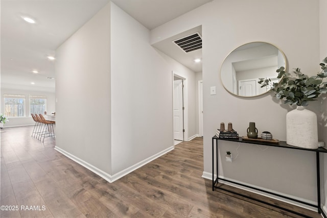 corridor featuring recessed lighting, visible vents, baseboards, and wood finished floors