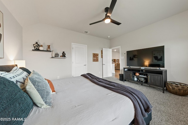 carpeted bedroom featuring visible vents, vaulted ceiling, and a ceiling fan