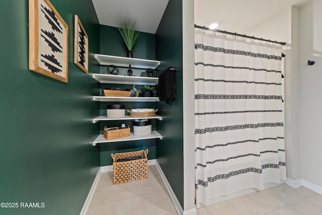 bathroom with tile patterned flooring, a shower with shower curtain, and baseboards