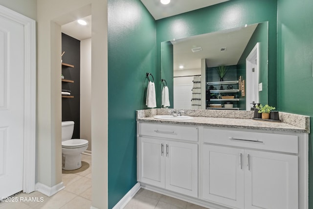 bathroom with toilet, tile patterned floors, baseboards, and vanity