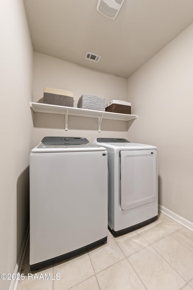 clothes washing area featuring laundry area, baseboards, visible vents, and washer and dryer