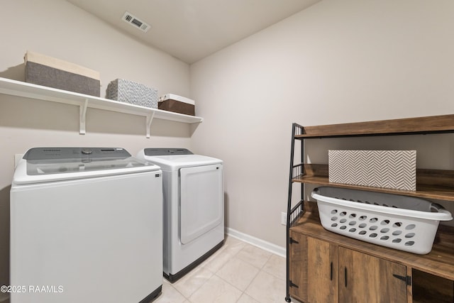 laundry room featuring laundry area, visible vents, baseboards, washing machine and dryer, and light tile patterned flooring