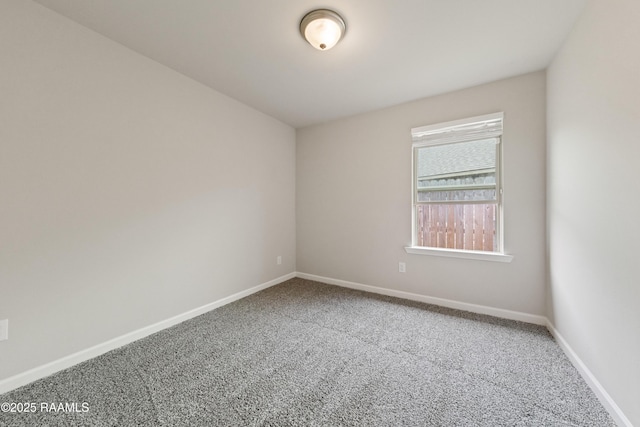 carpeted spare room with baseboards