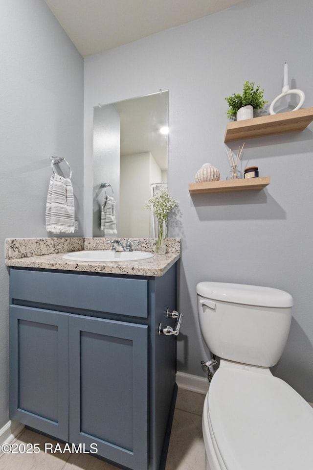 half bathroom featuring toilet, tile patterned flooring, baseboards, and vanity