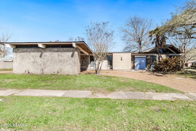 view of front of property featuring a front lawn and stucco siding