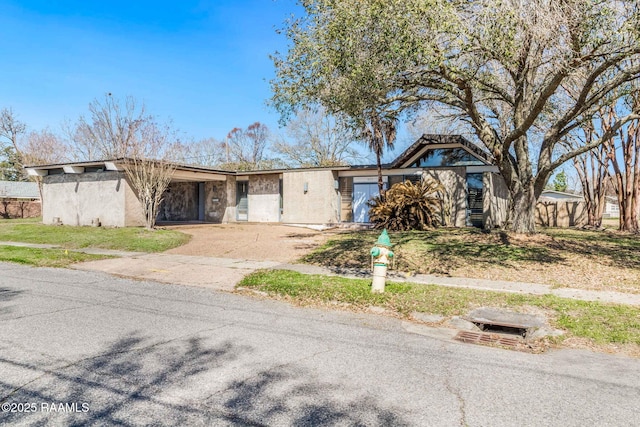 view of front facade featuring a carport, driveway, and stucco siding