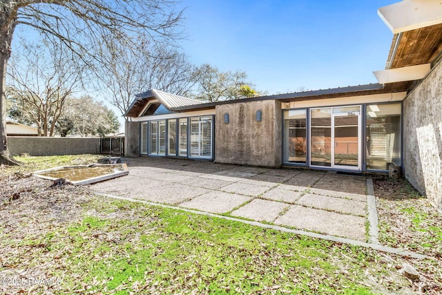 back of house with metal roof, stucco siding, a patio, and fence