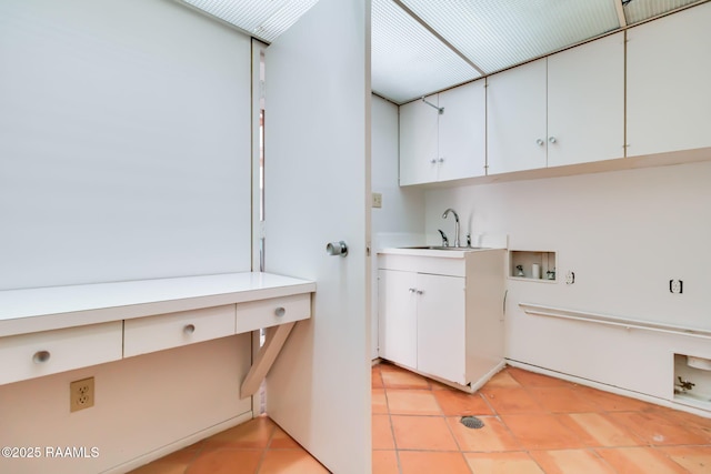 washroom featuring cabinet space, light tile patterned floors, washer hookup, and a sink