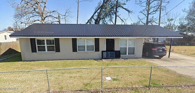 ranch-style home with a fenced front yard, an attached carport, brick siding, and driveway