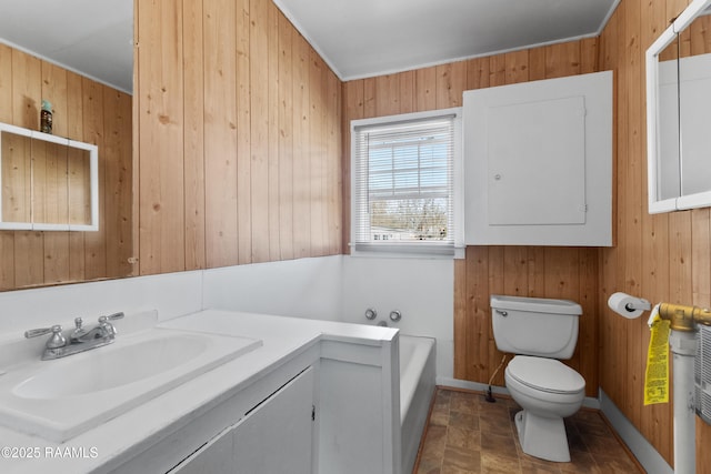 bathroom with electric panel, toilet, wood walls, and vanity