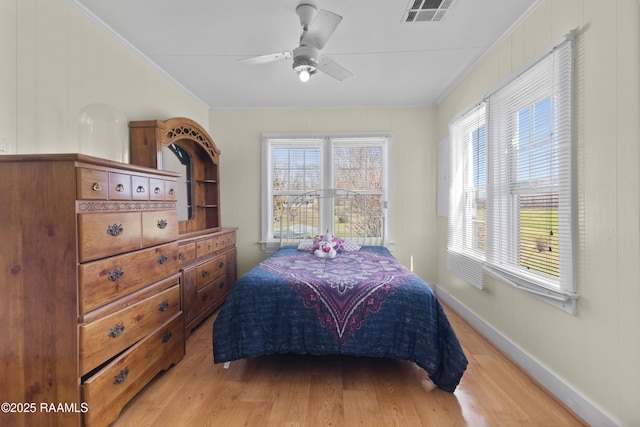 bedroom featuring visible vents, multiple windows, ornamental molding, and light wood finished floors