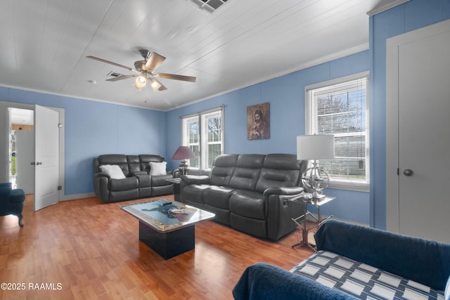 living area with crown molding, light wood-style flooring, a ceiling fan, and visible vents