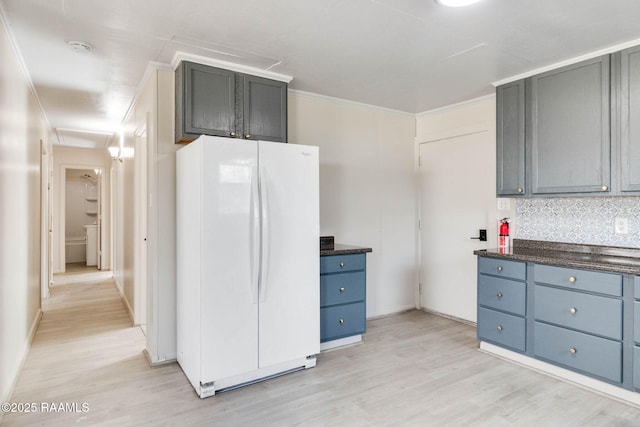 kitchen with light wood-style flooring, ornamental molding, backsplash, and freestanding refrigerator