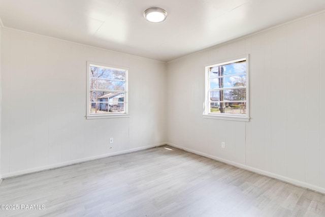 empty room with baseboards, a wealth of natural light, and wood finished floors