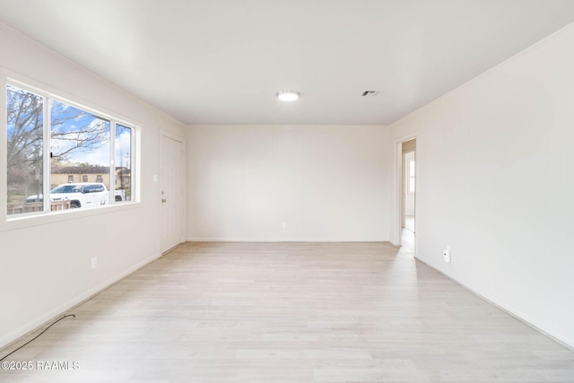 spare room featuring visible vents and light wood finished floors