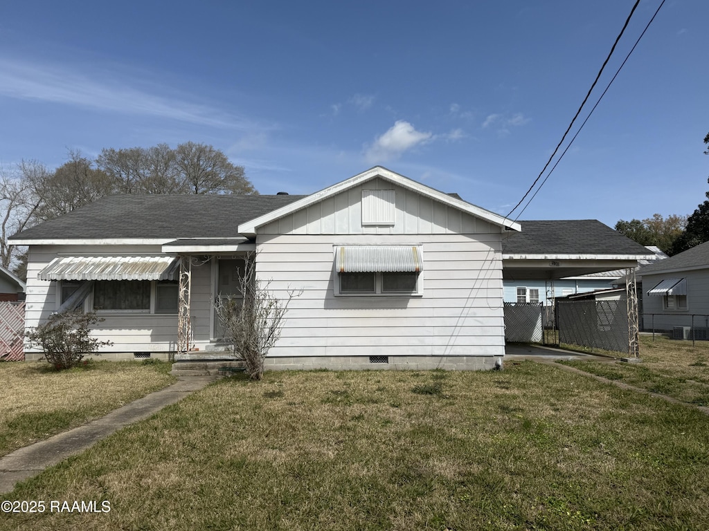 view of front of house with a front yard and a shingled roof