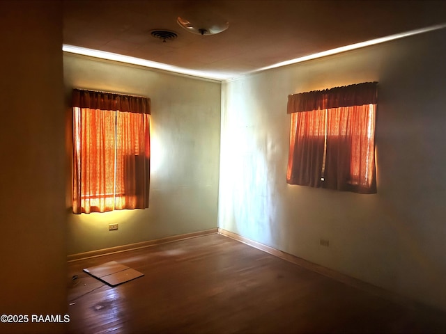 unfurnished room with baseboards and wood finished floors