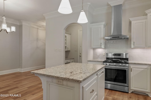 kitchen with ornamental molding, stainless steel gas stove, and wall chimney exhaust hood