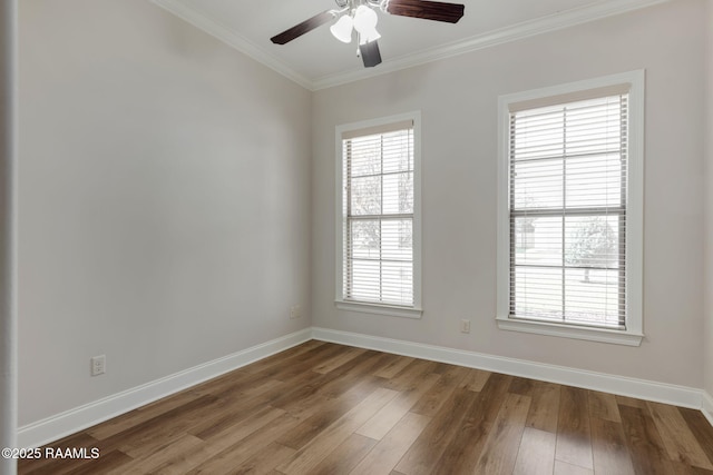 unfurnished room with a healthy amount of sunlight, baseboards, crown molding, and wood finished floors