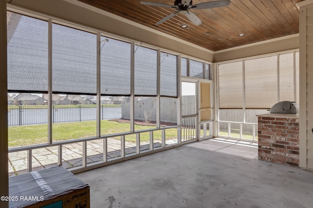 unfurnished sunroom featuring a water view, wood ceiling, and a ceiling fan