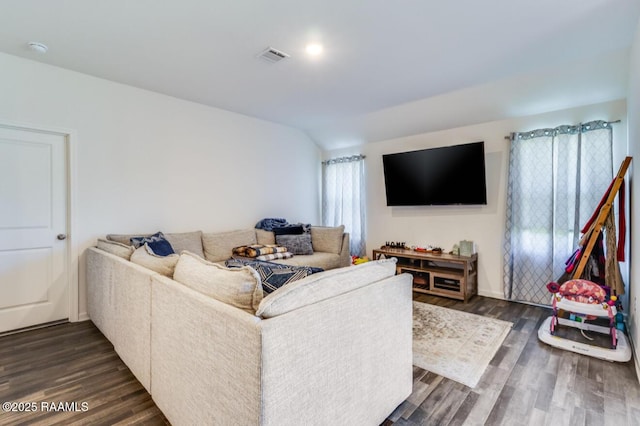 living area featuring vaulted ceiling, dark wood finished floors, and visible vents