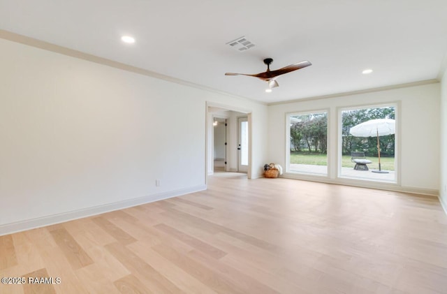 empty room with baseboards, light wood-style floors, visible vents, and crown molding