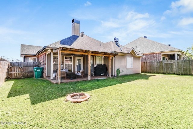 back of property featuring a patio, a yard, an outdoor fire pit, and a fenced backyard